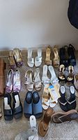 Wide view showing assortment of women's heels and flats arranged on carpeted floor