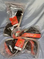 Package of three black 100% human hair wigs in clear plastic bags with red labels showing brand and features