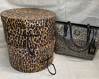 Two round leopard print hat boxes placed next to leopard print Anne Klein purse with black handles and gold-tone logo plaque.