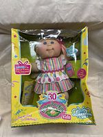 Full view of Cabbage Patch Kids 30-year celebration doll in original yellow box with visible box damage