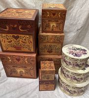 Group photo showing 6 nesting boxes with folk art designs and 4 round floral storage boxes.
