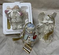 Photo of three Lenox porcelain Christmas ornaments: snowman, angel, and Santa in original packaging.