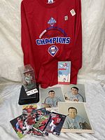 Red long sleeve 2008 Phillies World Series Champions jersey displayed with boxed Ryan Howard bobblehead, autographed photos, and assorted Phillies baseball cards on white backdrop.