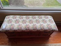 Top view showing the floral upholstered cushioned top and cedar lined storage bench shape.