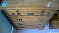 Full view of Vilas wooden chest of drawers showing four drawers with metal handles and knobs.