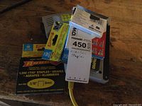 Image showing the electric stapler with attached label and multiple unopened Arrow staple packs beneath it.