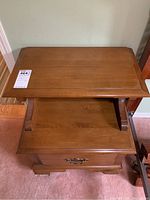 Wooden night stand showing top view with raised shelf and flat surface below