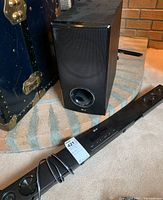 Photo of LG subwoofer and LG sound bar placed on floor showing overall appearance.