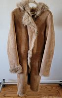 Front view of the women’s shearling coat showing zip front, shearling trim on hood, cuffs, and edges.