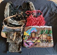 Photo of 5 handbags and purses grouped together on dark background showing variety of styles and materials.