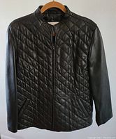Front view of black Pamela McCoy women's leather jacket with diamond quilting on front, zipper closure, and stand collar.