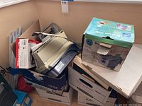 Photo of boxed Brother Intellifax 1270e fax machine and other office items piled in boxes