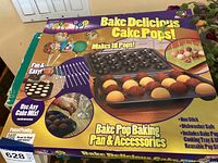 Box of Bake Pop Cake Pop Baking Pan and Accessories showing the product features and images of cake pops.
