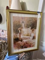 Full view of framed wall art showing garden scene with visible frame scratches