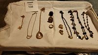 Overview photo of all necklaces, rings, and earrings in the lot arranged on cloth.