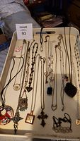 Full tray containing 17 assorted fashion necklaces in various chain styles and pendant designs.