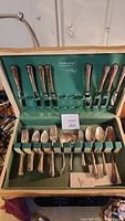 Photo of the full flatware set in original box, showing handle design and arrangement.