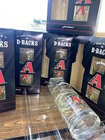 Twelve glasses boxed in original Jack Daniel's and Arizona Diamondbacks branded packaging, boxes show wear.