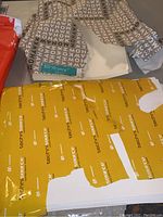 Paper sheets in partial ream with TechniSource yellow packaging and 50-10 ultra patterned paper on top