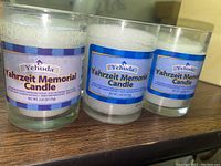 Front view of three Yehuda Yahrzeit Memorial candles showing labels and sizes in glass containers.