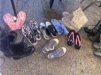 Photo showing a variety of women's and children's shoes including boots, sneakers, sandals, slippers, some with tags.