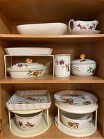 Top shelf plain baker and gravy boat with saucer on wooden cabinet shelf