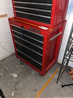 Front view of red Craftsman bottom tool box on wheels showing four drawers and lock with keys.