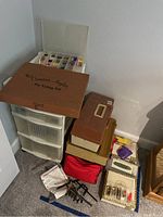 Overview of wooden kit box, spool storage, tackle boxes, vice, red bag and lure box