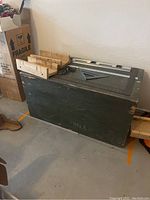 Wooden foot locker with woodworking tools on top, showing size and condition.