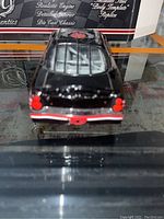 Rear view of the black Dale Earnhardt Drakkar Noir die-cast car showing rear lights and detailed bumper.