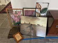 Photo showing the collection of wall art including stained glass panel, metal leaf hanging, wood hangings, and an abstract painting.