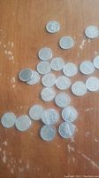 Several 1960s Canadian quarters spread on a wood surface with visible wear and some scattered placement, showing coin heads and tails sides.