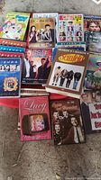 Photo showing assortment of DVD series including Family Guy, Friends, Bones, Glee, MacGyver, Breaking Bad, Seinfeld, Lucy Show, and more.