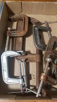 Box of various metal clamps including rusty and clean clamps in different sizes