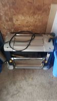 Front view of Mastercraft benchtop thickness planer showing silver top, blue base, depth adjustment knob and coiled power cord.