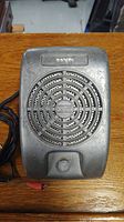 Front view of antique metal drive-in theatre speaker showing grille, logo, and volume knob.