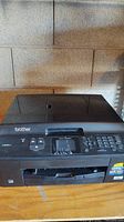 Front view of Brother black multifunction printer scanner copier with display and control panel.