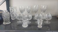 Full set of 16 heavy crystal glassware pieces including glasses and containers.