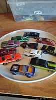 All 11 Hot Wheels cars arranged on a plate, showing different models and colors.
