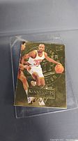 Front side of the Kenny Smith gold basketball card featuring action image and gold embossed design, showing wear at edges and corners.