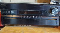 Front view of Onkyo TX-SR805 THX receiver showing power button, source selection buttons, digital display, and master volume knob.