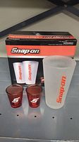 Full set showing two frosted pint glasses, two red shot glasses, and the Snap-on branded box.