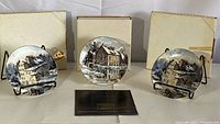Lot of three Keirstead "Famous Mills" collector series plates displayed with original boxes and chains for hanging, plates shown from front with winter mill scenes.
