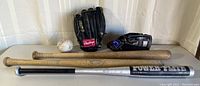 View of full baseball equipment lot including two bats (Power-Flite aluminum and Louisville Slugger wood), two black baseball gloves (Rawlings and Spalding), and a baseball ball.