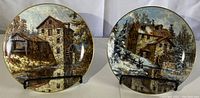 Two collector plates from Keirstead Sisters series side by side, showing both artworks by Brenda and Janice Mills with gold rims.