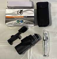 Photo showing the boxed telescope with carrying case, tripod wrapped in plastic, phone mount, and telescope lying flat.