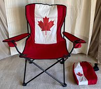 Folding lawn chair with Canadian flag on backrest, red and white fabric with red maple leaf in the middle. Included original red and white carry bag with matching maple leaf design is seen beside the chair.