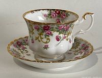 Front view showing the floral and gold detailed tea cup on its matching saucer.