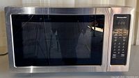 Front view of stainless steel KitchenAid microwave with digital display and control panel on the right.