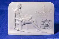Full view of the bisque plaque showing the seated man reading and embossed Lladró Collector's Society logo with signatures.